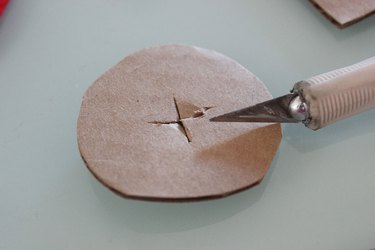 cutting an x in the cardboard