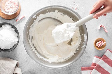 Whipped topping on a white spatula over a bowl