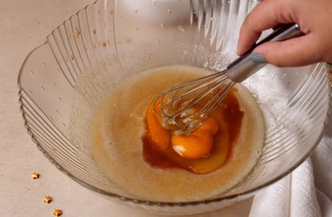 Whisking egg and vanilla extract in mixing bowl