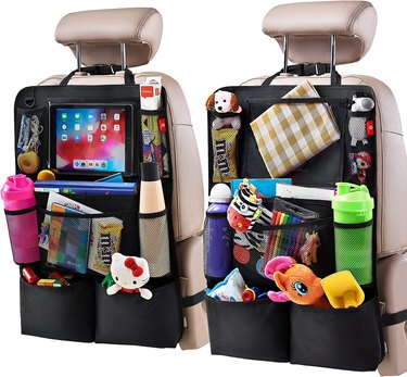 Two black backseat organizers full of items, strapped to front seats