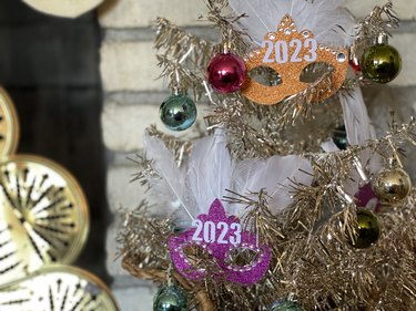 A closeup of sparkling New Year's masks on a tinsel tree