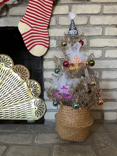 A tinsel tree covered with New Year's Eve masks, baubles and decor.