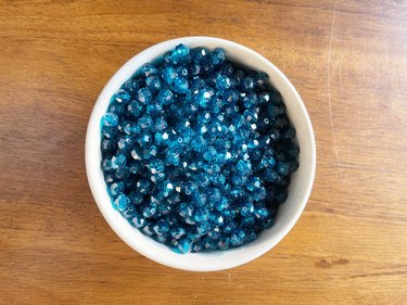 A white bowl filled with blue beads