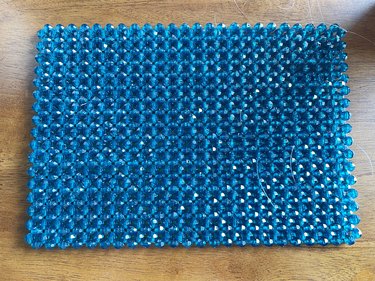 A large beaded rectangle made out of blue plastic beads