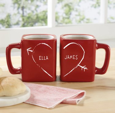 Two red mugs with half heart and names
