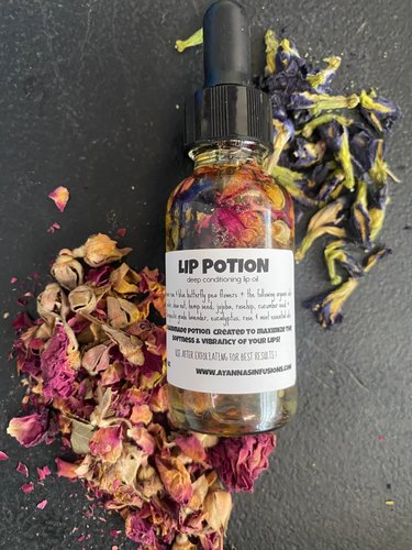 A glass tincture bottle featuring serum, dried flower petals and the words "Lip Potion."