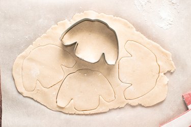 Cutting cookie dough with sweater cookie cutter