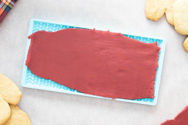 Pressing maroon cookies into a silicone mold