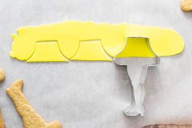 Cutting yellow fondant with a leg lamp cookie cutter