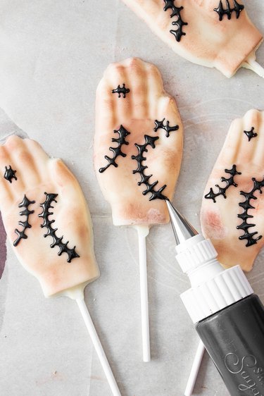 Decorate hand lollipops with edible dust and royal icing