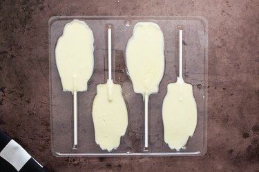 Fill hand lollipop mold with melted white chocolate