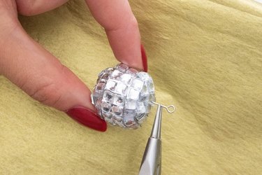 Insert eye pin into mini disco ball to make a charm