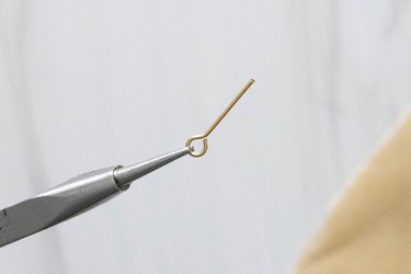 Jewelry pliers holding an eye pin