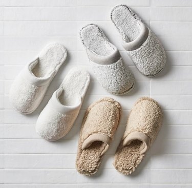 Three pairs of fuzzy sherpa slippers in white, gray and brown
