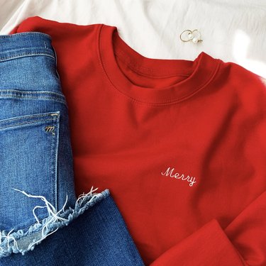 red sweatshirt with "merry" embroidered on it