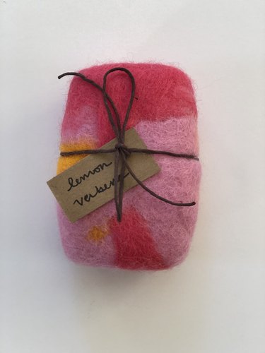 One bar of pink and yellow felted soap with a tag reading "lemon verbena"