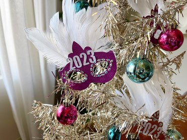 A close up of a christmas tree with a mask on it. Mardi gras tree