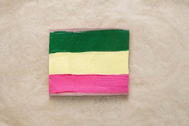 Paint brown clay coaster with green, yellow and pink paint