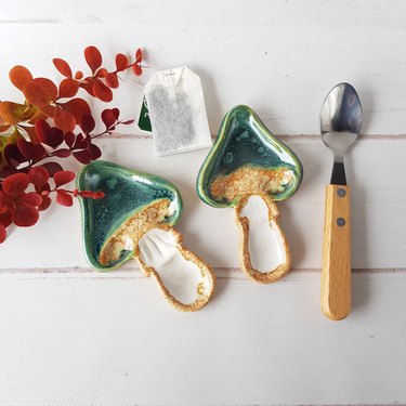 Two emerald green mushroom-shaped ceramic tea bag holders