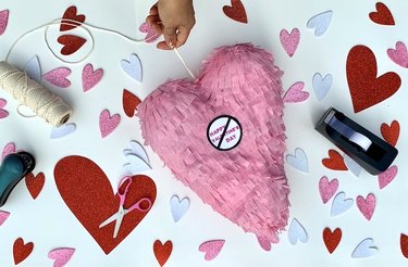 Heart piñata against of a backdrop of scattered hearts and art supplies