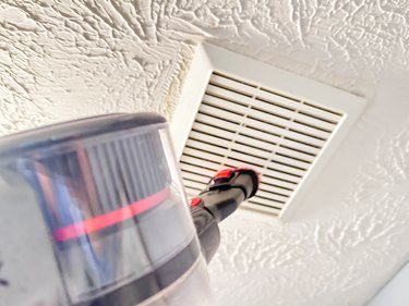 vacuuming a bathroom exhaust fan