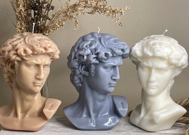 Three candles shaped like busts of Michelangelo's "David"
