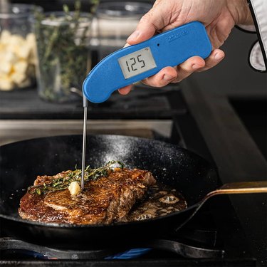 Thermoworks Thermapen One checking the temperature of a steak in a skillet