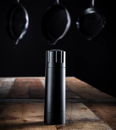 Männkitchen grinder on a butcher-block surface, with a dark background