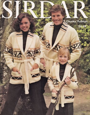 Two adults and a child wearing white and brown cardigans with pockets and belts