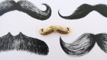 Gold pin shaped like a mustache