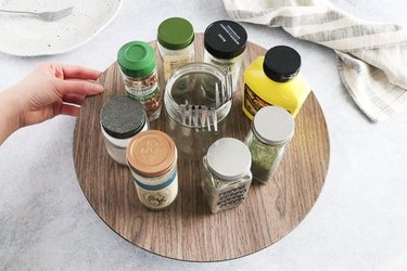 DIY lazy Susan with jars of spices and utensils in a Mason jar