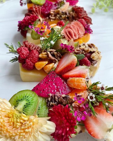 Blocks of cheese topped with fruit and flowers
