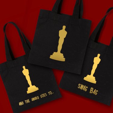 Three black canvas bags featuring gold statues