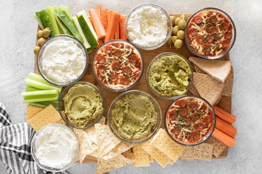 Dip board with pepperoni pizza dip, whipped feta and guacamole hummus