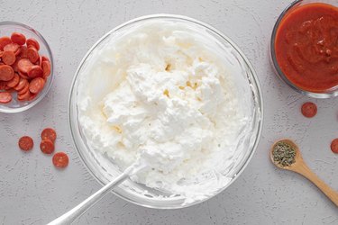 Combine sour cream, cream cheese and mozzarella cheese in a bowl