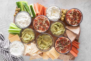 Super Bowl dip board with pepperoni pizza dip, whipped feta and guacamole hummus