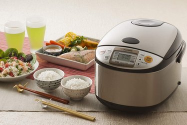 Zojirushi rice cooker and warmer, 10-cup model, shown next to rice, veggies, and fish that you can cook in it.