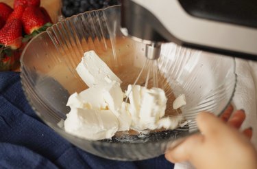 Using an electric mixer to beat cream cheese
