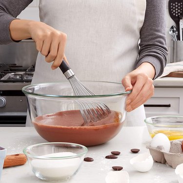 woman whisking brownie batter with OXO balloon whisk