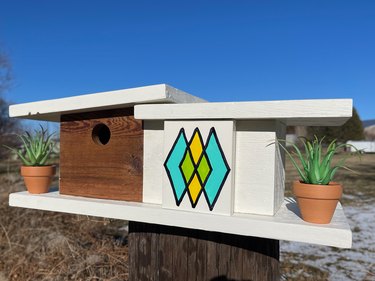 finished midcentury modern birdhouse outside