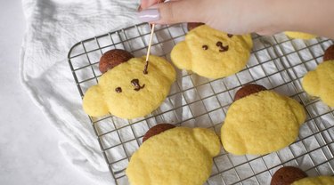Decorating Pompompurin cookies with melted chocolate.