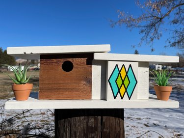 finished midcentury birdhouse mounted outside