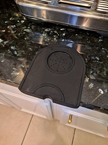A silicone tamper mat attached to the edge of a countertop