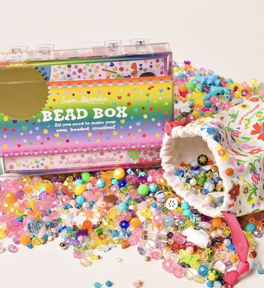 Susan Alexandra bead box, showing the box, tons of scattered beads, and a little pouch with a floral pattern on it.