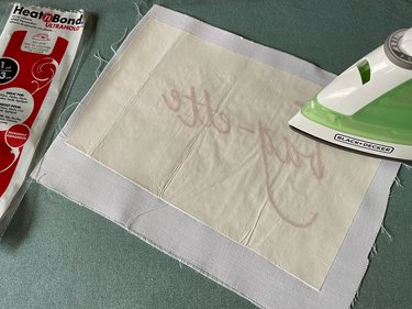 Adhere iron-on adhesive to back of embroidery with an iron