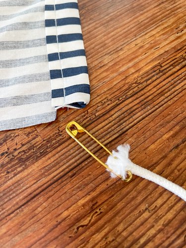 Attach safety pin to drawstring cord