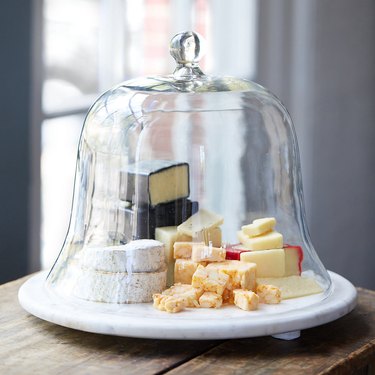 Marble and glass serving cloche with different cheeses stored inside