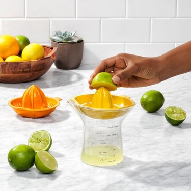 OXO citrus juicer with lemons and limes on a marble counter