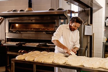 Man in white shirt bakes sourdough bread