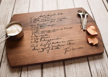 Brown wood cutting board engraved with a handwritten recipe